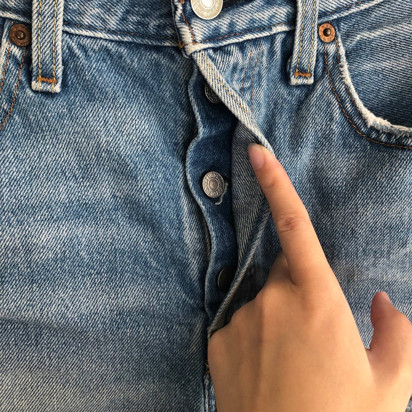 Levi's 501 medium wash distressed cutoff raw hem button fly denim jean shorts
